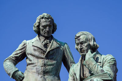 Low angle view of statue against blue sky