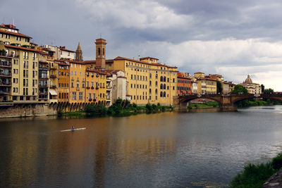 Residential district by arno river against sky