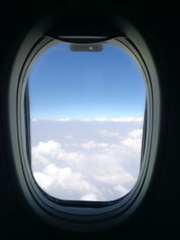 View of cloudy sky seen through airplane window