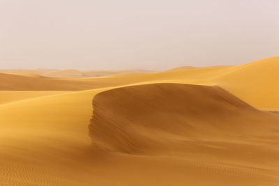 Sand dune in desert against clear sky