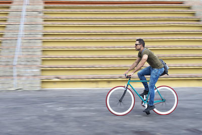 Low section of man riding bicycle on street