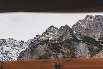 Rocks on snowcapped mountains against sky