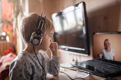 Boy talking with grandmother within video chat on laptop, life in quarantine time, self-isolation
