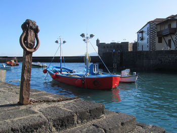 Sailboats moored on sea against clear sky