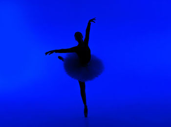 Low angle view of bird flying against blue background