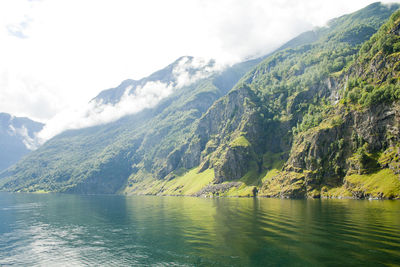 Scenic view of lake by mountains against sky