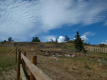 View of field against cloudy sky