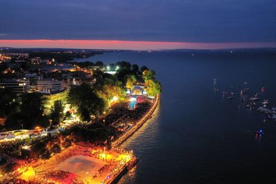 High angle view of illuminated city at sunset