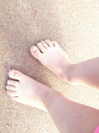 Low section of person standing on sand