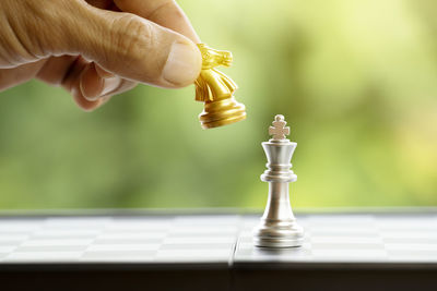 Cropped hand playing chess outdoors