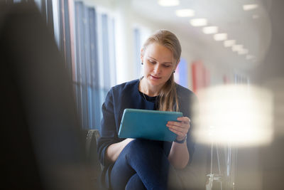 Young woman using digital tablet in airport