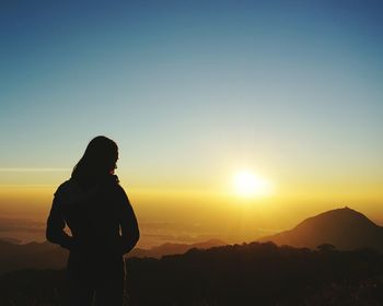 Silhouette of man against sunset sky