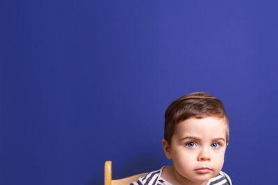 Close-up of boy against blue background