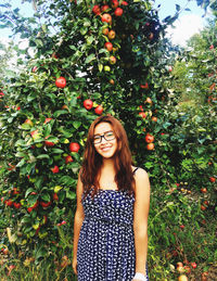 Portrait of teenage girl standing against plants