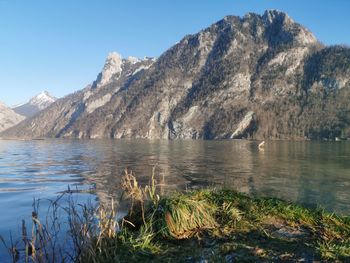 Scenic view of lake by mountains against clear sky