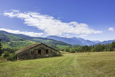 Scenic view of field and mountains against sky