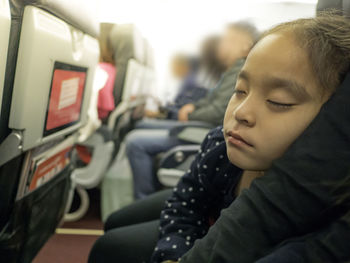 Close-up of cute girl sleeping in airplane