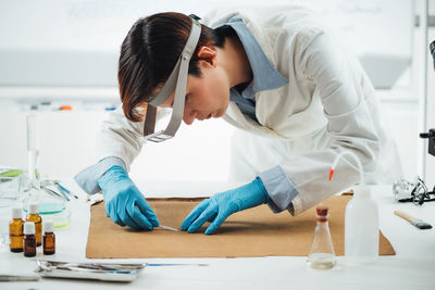 Professional conservator removing the dirt from reverse side of the antique oil painting canvas