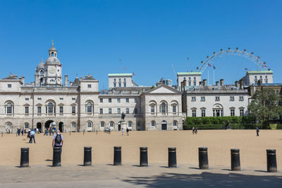 Buildings in city against clear blue sky