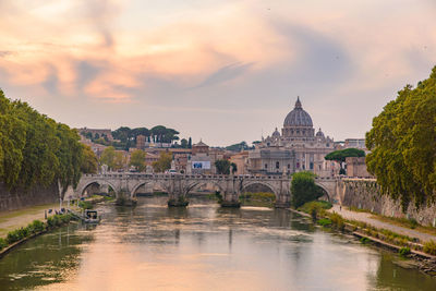 Arch bridge over river against cloudy sky