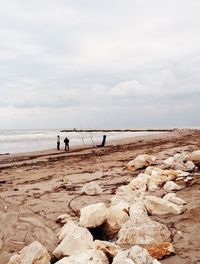 People on beach against sky