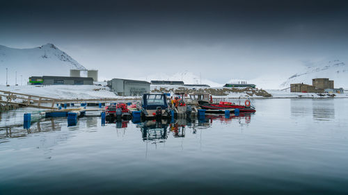 Boats moored in lake against sky