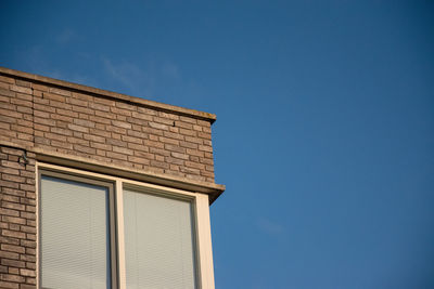 Low angle view of building against clear blue sky