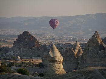 View of hot air balloon flying over mountain in cappadocia, turkey