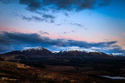 Scenic view of snowcapped mountains against sky during sunset