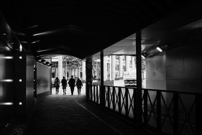 Rear view of people walking on footpath in building