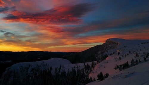 Scenic view of snowcapped mountains against sky during sunset