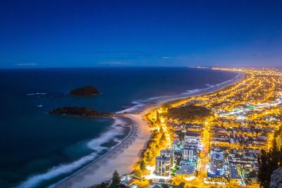 High angle view of illuminated sea against blue sky