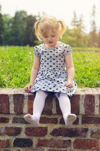 Full length of girl sitting on railing at park