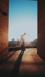 Rear view of man on street against buildings in city