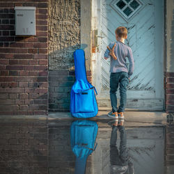 Rear view of man walking against building