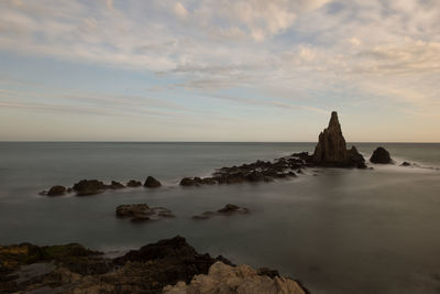 Scenic view of rocks in sea against sky