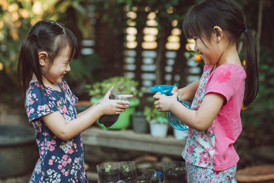 Side view of girls watering plants