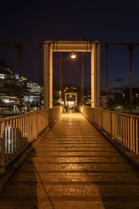 Illuminated bridge against sky at night