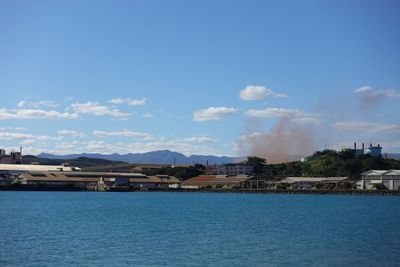 Scenic view of sea by buildings against sky