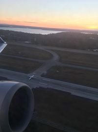 Airplane wing against sky during sunset