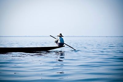 Rear view of man rowing boat