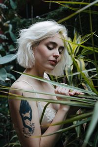 Young woman wearing lingerie standing by plants