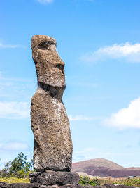 Statue against rock formation against sky