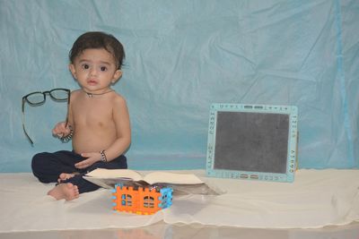 Cute boy sitting on toy at home