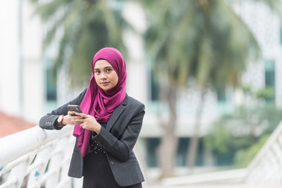 Young businesswoman wearing hijab using smart phone