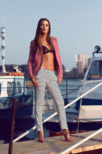 Full length of beautiful woman standing on pier