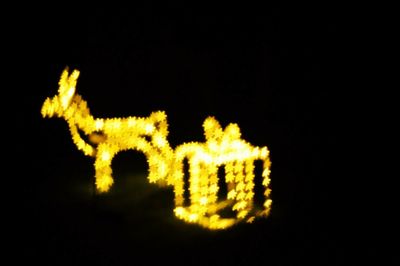 Close-up of illuminated lamp over black background