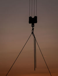 Low angle view of silhouette telephone pole against sky during sunset