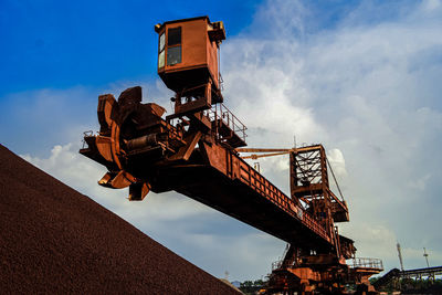 Low angle view of crane against sky