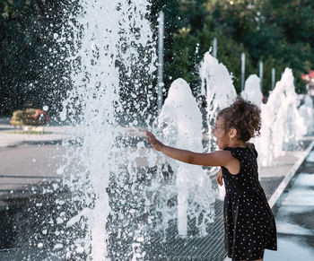 Side view of girl at fountain